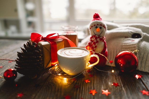 Tazza di caffè natalizia con maglione e decorazioni natalizie