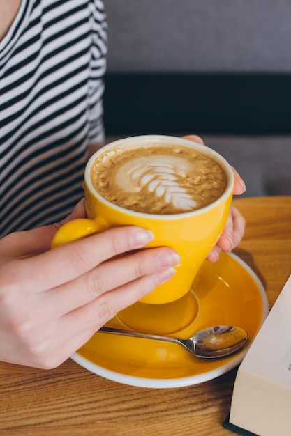 Tazza di caffè nelle mani della ragazza