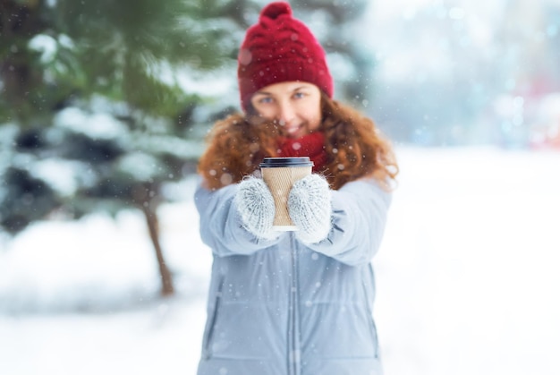 Tazza di caffè nelle mani di una bella ragazza. Ritratto di giovane bella ragazza con una tazza di caffè calda.