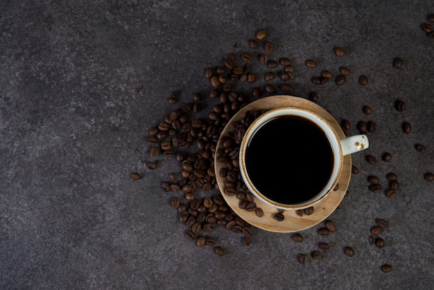 Tazza di caffè nero con chicchi di caffè intorno, vista dall'alto