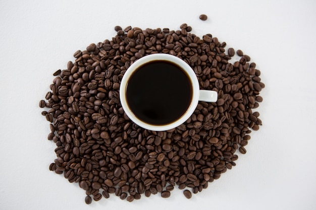 Tazza di caffè nero con chicchi di caffè tostati