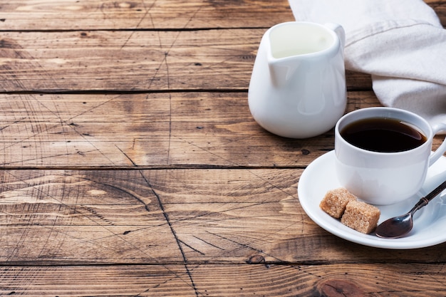 Tazza di caffè nero e latte su uno sfondo di legno