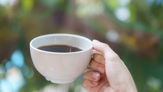 Tazza di caffè o tè in mano della donna