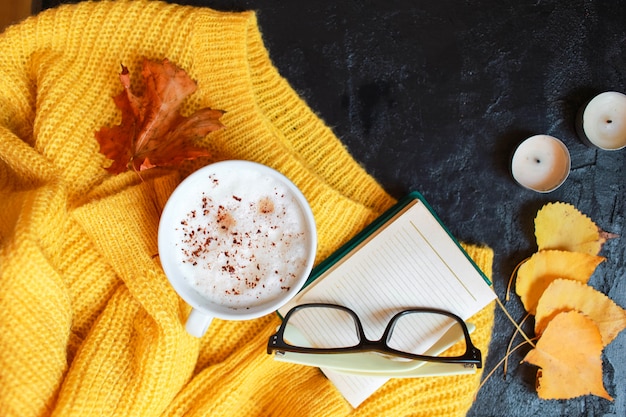 Tazza di caffè, occhiali e un maglione giallo brillante