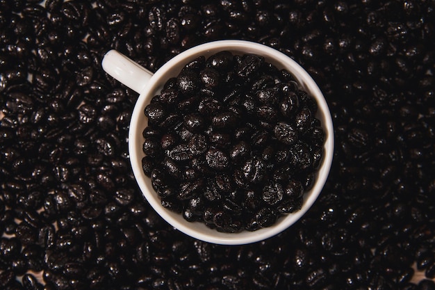 Tazza di caffè piena di chicchi di caffè sulla superficie del chicco di caffè Spazio di copia Messa a fuoco selettiva