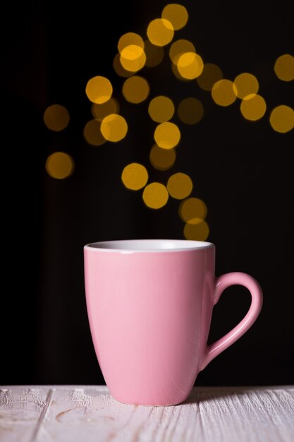 Tazza di caffè rosa e bokeh sullo sfondo