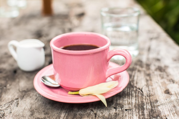 Tazza di caffè rosa sulla tavola di legno