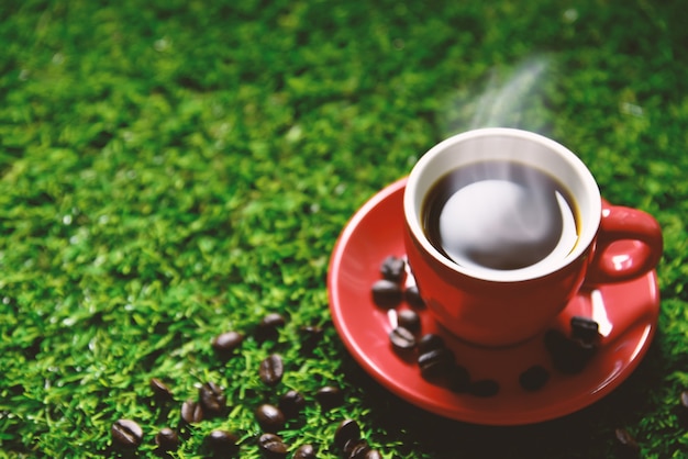 Tazza di caffè rossa sull&#39;erba verde