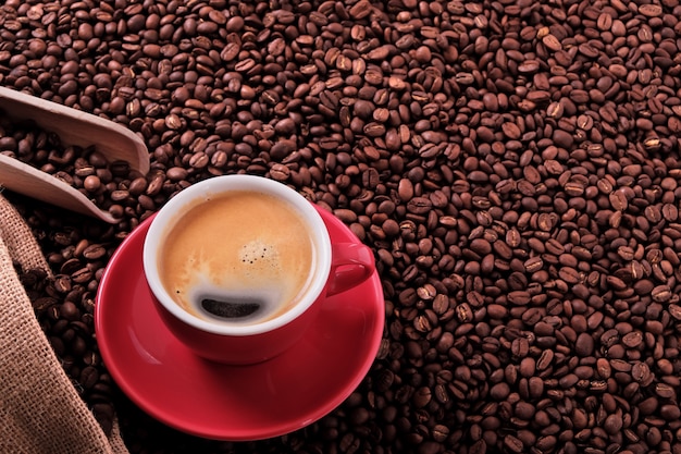 Tazza di caffè rosso con caffè espresso e semi tostati