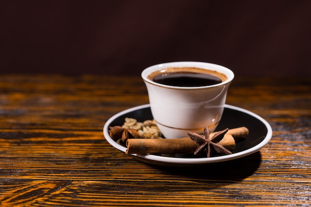 Tazza di caffè scuro forte con varietà di spezie