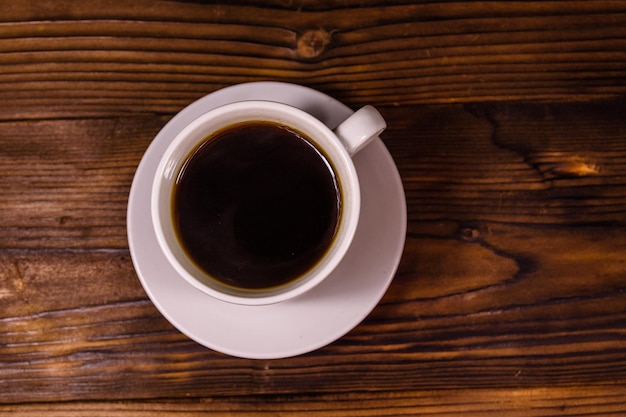 Tazza di caffè scuro sulla tavola di legno rustica. Vista dall'alto