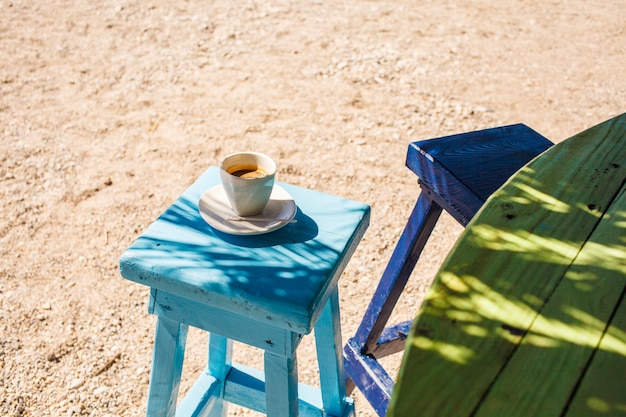 Tazza di caffè su una sedia sulla spiaggia in un caffè