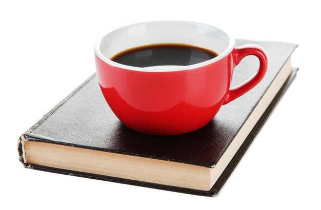 Tazza di caffè sul libro isolato su bianco
