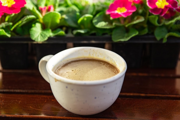 tazza di caffè sul tavolo all'aperto e fiori primula multicolore copia spazio cibo sfondo