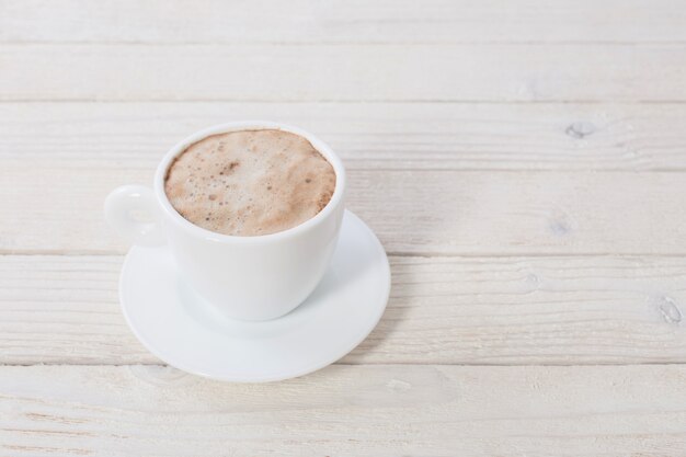 Tazza di caffè sul tavolo di legno bianco