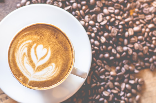 Tazza di caffè sul tavolo in legno con chicco di caffè