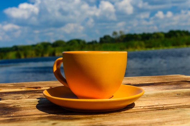 Tazza di caffè sul tavolo in legno rustico in riva al fiume