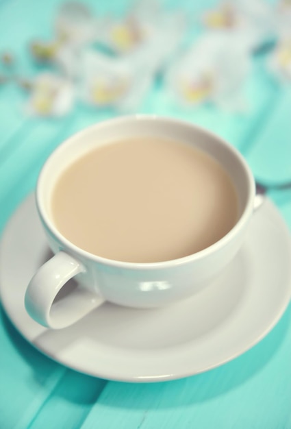 Tazza di caffè sul vecchio tavolo in legno vista dall'alto con fiori freschi di primavera