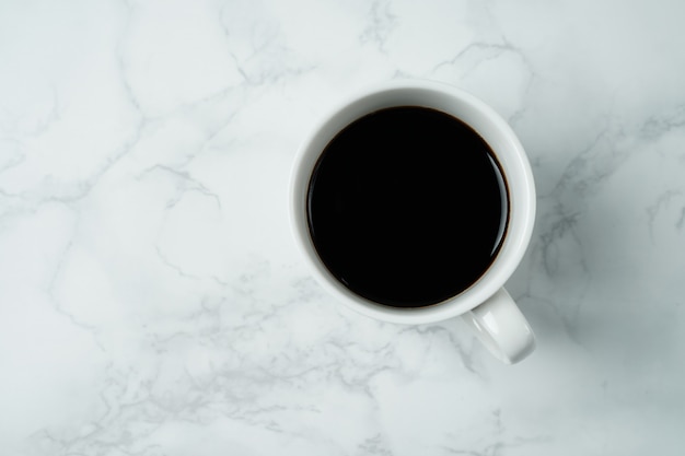 Tazza di caffè sulla tabella di struttura di marmo, tazza di caffè nero nella vista superiore
