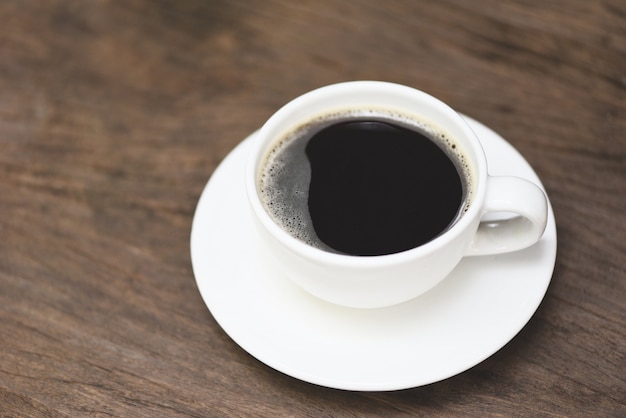 Tazza di caffè sulla tavola - caffè nero in tazza bianca su fondo di legno