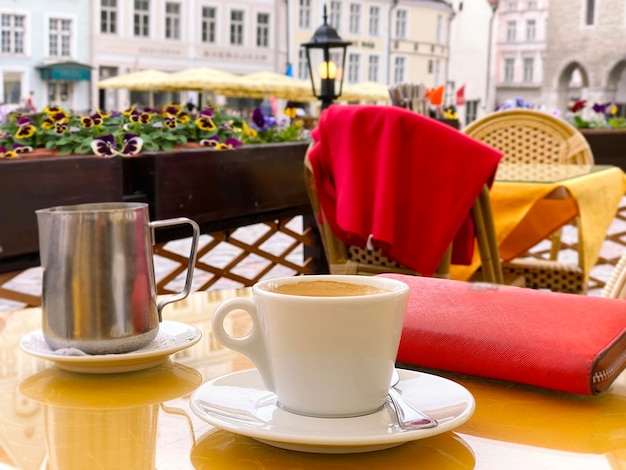 tazza di caffè sulla tavola del caffè della via della città nella città vecchia di Tallinn