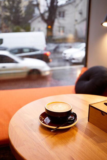 Tazza di caffè sulla tavola di legno nella caffetteria Cappuccino o latte in tazza Godersi il tempo da solo