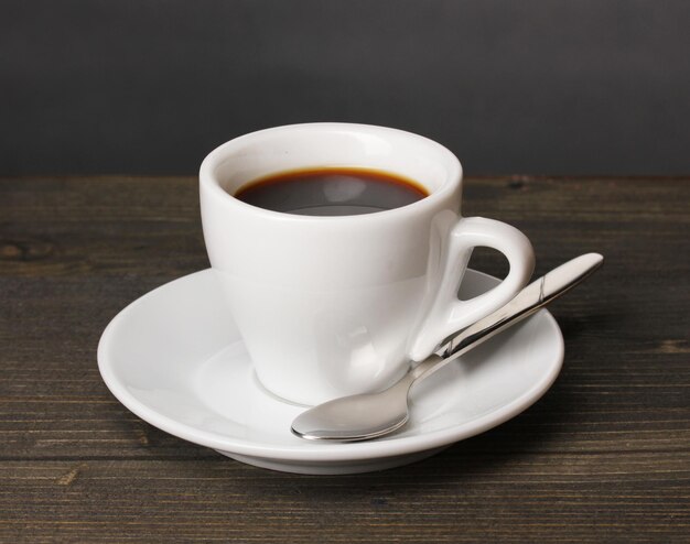 Tazza di caffè sulla tavola di legno su sfondo grigio