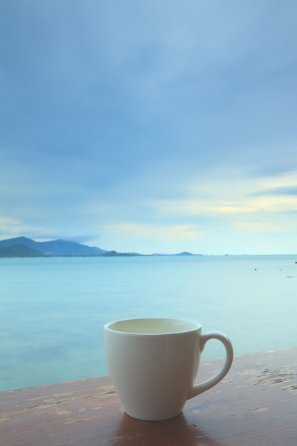 Tazza di caffè sulla terrazza del grunge su uno sfondo di vista sul mare