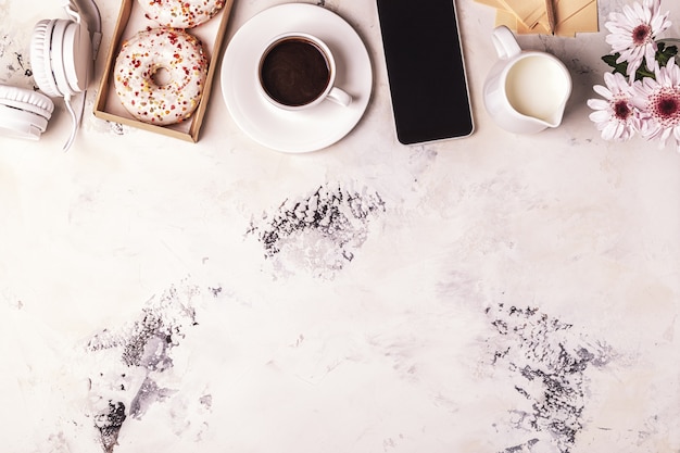 Tazza di caffè, telefono e cuffie