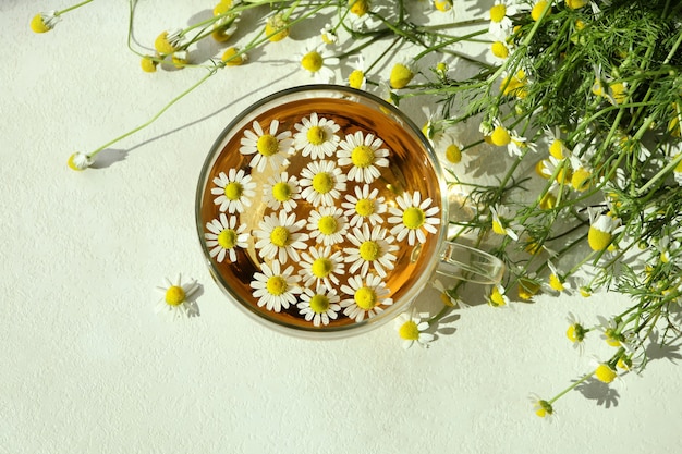 Tazza di camomilla sul tavolo strutturato bianco