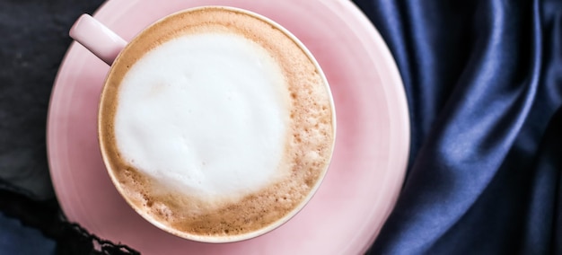 Tazza di cappuccino e gioielli di perle su caffè di lusso in tessuto di seta