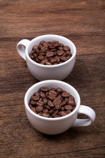 Tazza di chicchi di caffè sullo sfondo di legno marrone