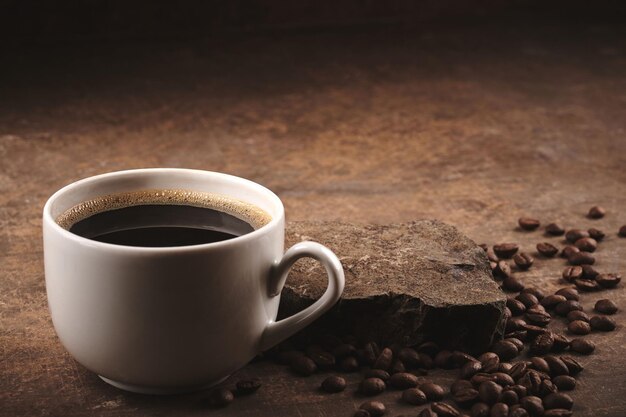 Tazza di chicchi di caffè tostati appena preparati su sfondo marrone