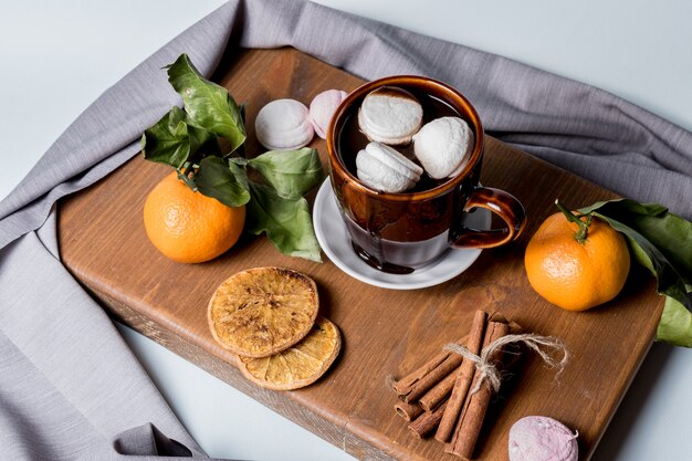 Tazza di cioccolata calda con marshmallow, cannella, frutta mandarino, frutta candita all&#39;arancia.