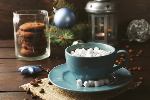 Tazza di cioccolata calda con marshmallow, ramo di abete su fondo di legno