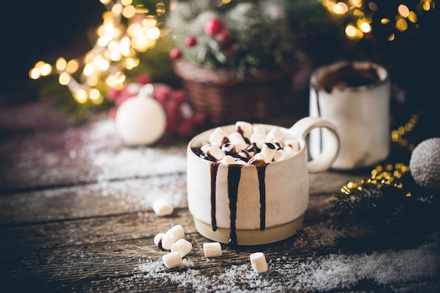 Tazza di cioccolata calda con marshmallow su sfondo di decorazioni natalizie