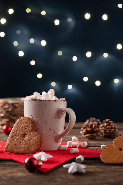 Tazza di cioccolata calda con piccoli marshmallow collocati in un ambiente festivo per le vacanze di Natale