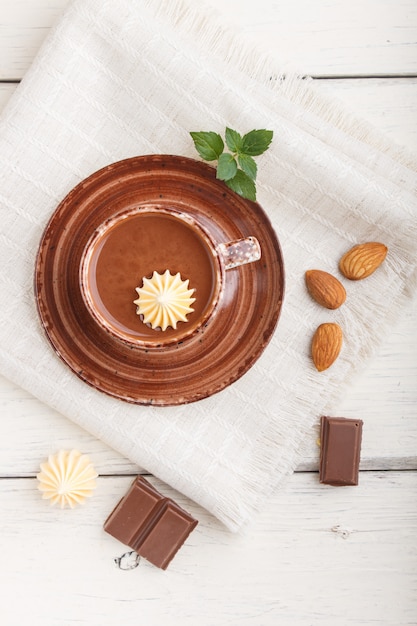 Tazza di cioccolata calda e pezzi di cioccolato al latte con mandorle