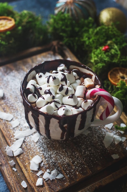 Tazza di cioccolata calda o cacao con marshmallow arance secche caramelle e cannella decorazione di natale o capodanno accogliente mattinata invernale messa a fuoco selettiva