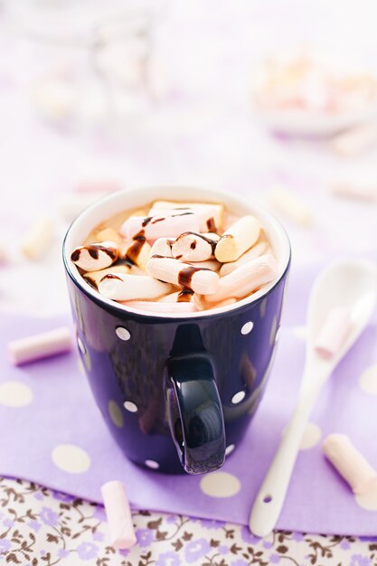 Tazza di cioccolata calda o cioccolato con marshmallow su un tavolo luminoso.