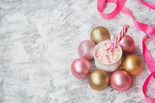 Tazza di composizione di Capodanno o Natale con marshmelow con caramelle tra i giocattoli luccicanti di Capodanno