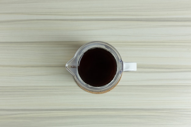 tazza di gocciolamento caffè sul tavolo bianco