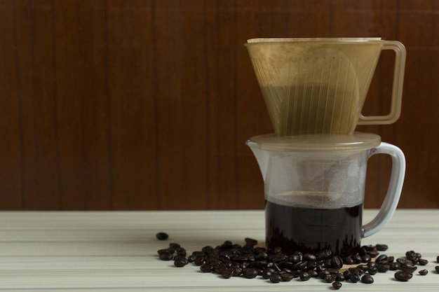 tazza di gocciolamento caffè sul tavolo bianco