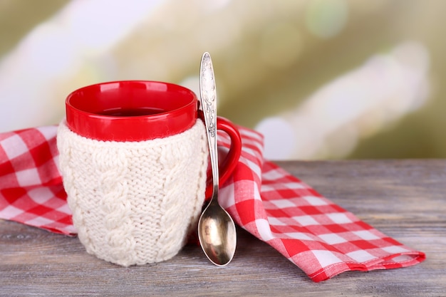 Tazza di gustoso tè caldo, su un tavolo di legno, su sfondo chiaro