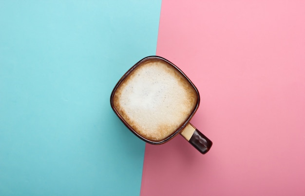 Tazza di latte o cappuccino su sfondo rosa blu pastello. Caffèlatte. Vista dall'alto