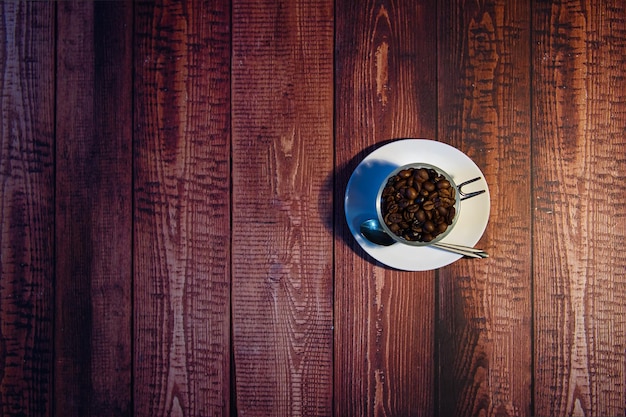 Tazza di porcellana bianca di concetto di giornata mondiale del caffè con chicchi di caffè