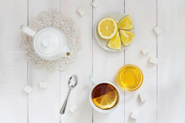 Tazza di tè al limone, miele e una teiera