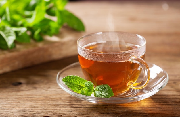 Tazza di tè alla menta sulla tavola di legno