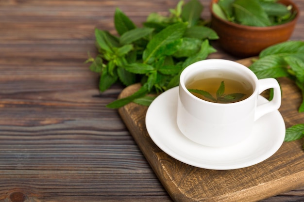 Tazza di tè alla menta sullo sfondo del tavolo Tè verde con vista dall'alto di menta fresca con spazio per la copia