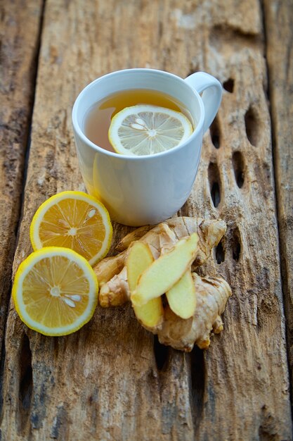 Tazza di tè allo zenzero con limone su legno